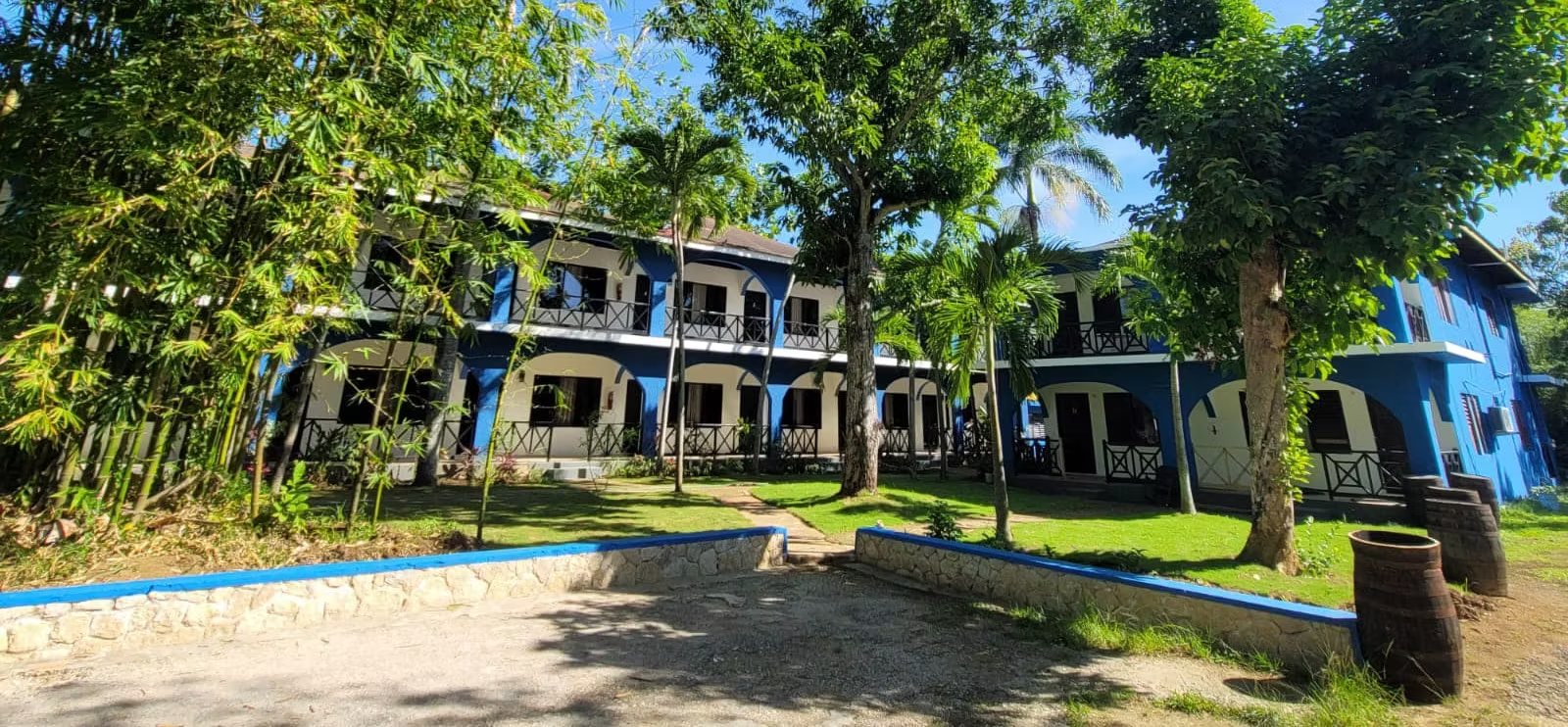 Blue and white guest buildings and garden at Rum Runners Resort
