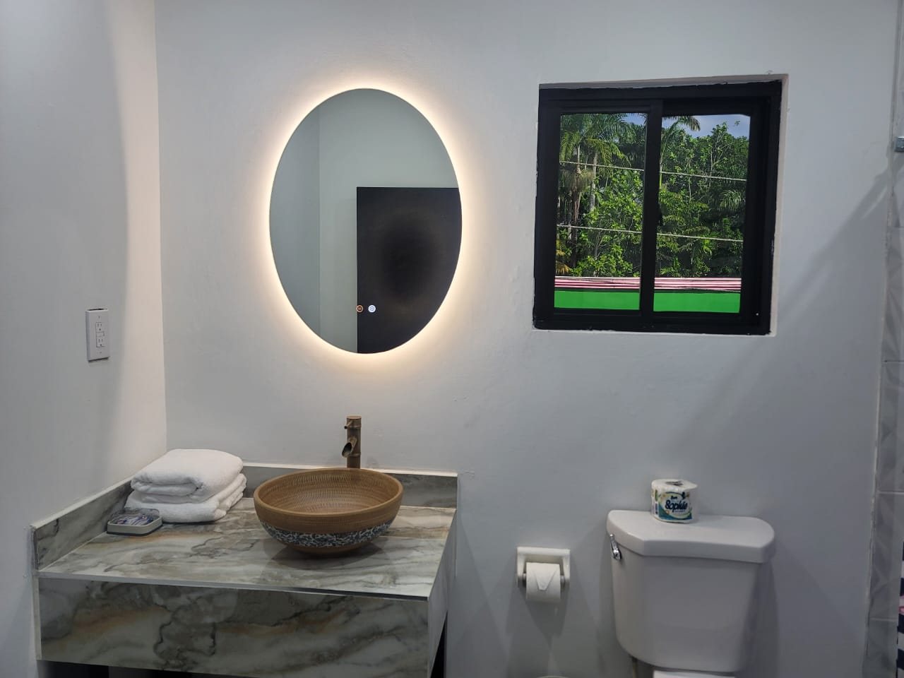 Private bathroom with lit mirror